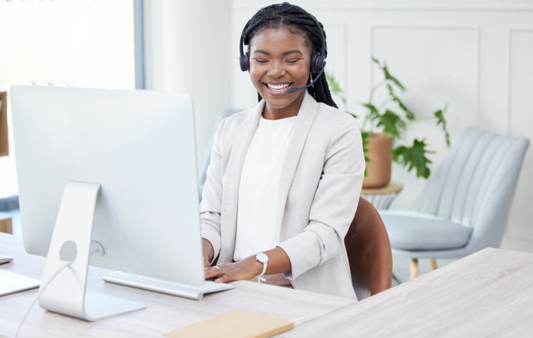 Always at your beck and call. Shot of a young african woman working on her PC in a call center.